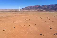 Untersuchungsflächen mit Feenkreisen und Euphorbien. Der weiße Pfeil zeigt auf die White Lady Lodge am Ugab-Fluss