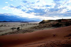 Sunrise at Dune Star Camp with a view of the Naukluft Mountains in the background
